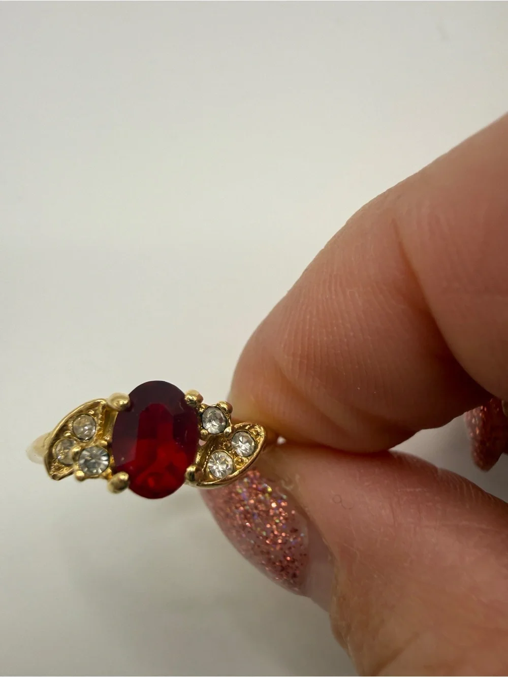 Gold Ring with Oval Red Center Stone and Clear Accent Stones